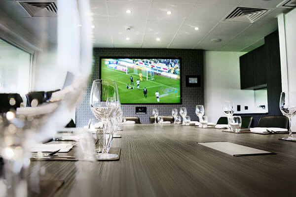 The Cinos Suite, showing the 80” NEC screen and AMX wall mounted panel.